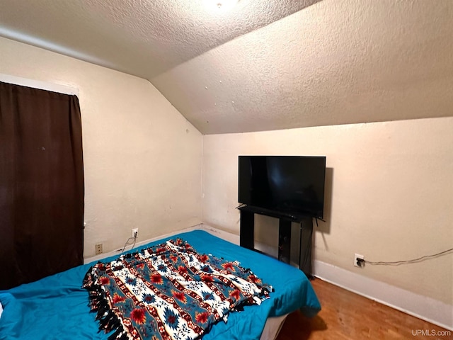 bedroom with carpet, vaulted ceiling, and a textured ceiling