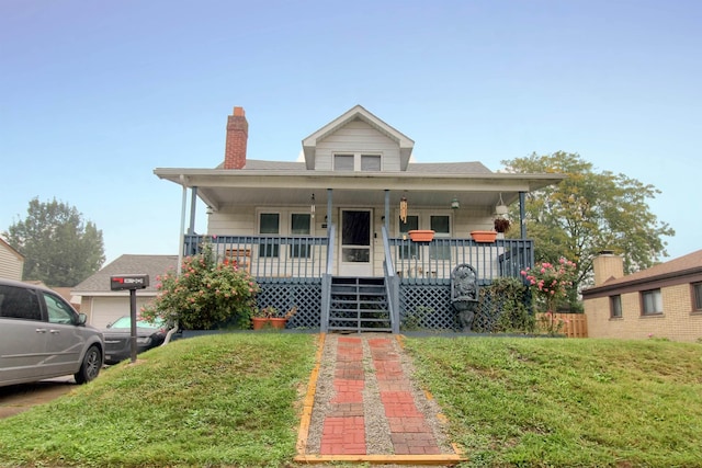 bungalow-style home featuring covered porch, a garage, and a front lawn