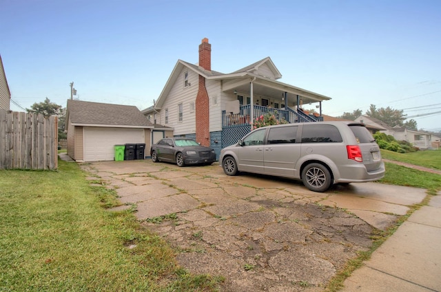 view of side of property featuring a lawn, a garage, and a porch