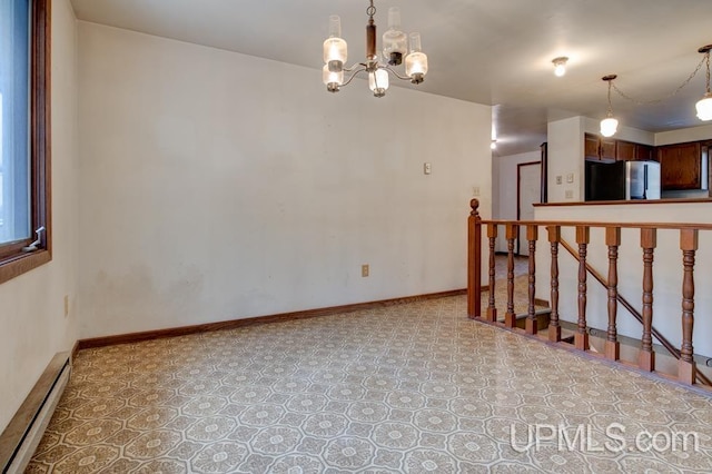 empty room with baseboard heating and a notable chandelier