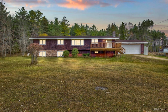 view of front of home featuring a deck, a yard, and a garage