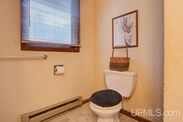 bathroom featuring baseboard heating and toilet