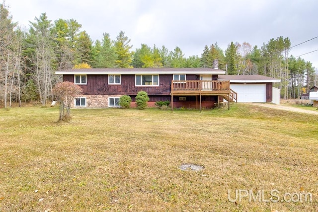 view of front of home with a front yard, a garage, and a deck