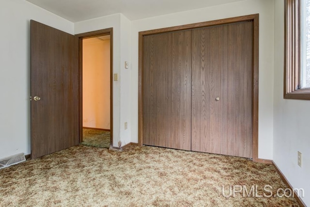 unfurnished bedroom with a closet and carpet flooring