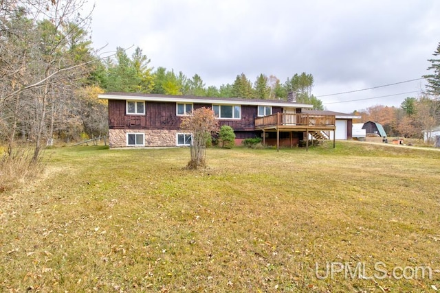 back of property with a deck and a lawn