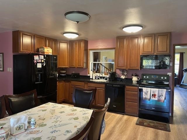 kitchen with black appliances, sink, and light wood-type flooring