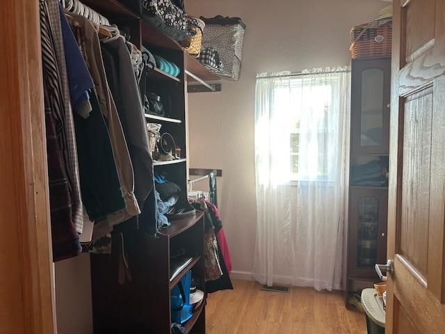 spacious closet with light hardwood / wood-style floors