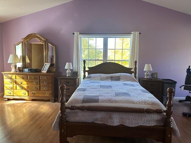 bedroom with vaulted ceiling and wood-type flooring