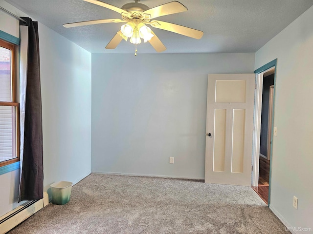 carpeted empty room featuring ceiling fan and baseboard heating