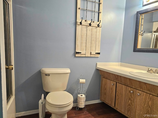 bathroom with hardwood / wood-style floors, vanity, and toilet