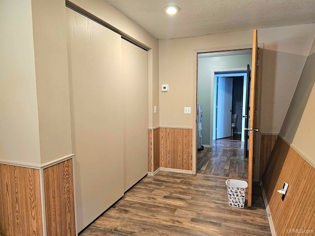 hall with dark hardwood / wood-style flooring and a textured ceiling