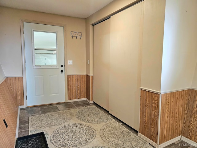 doorway to outside featuring wood walls