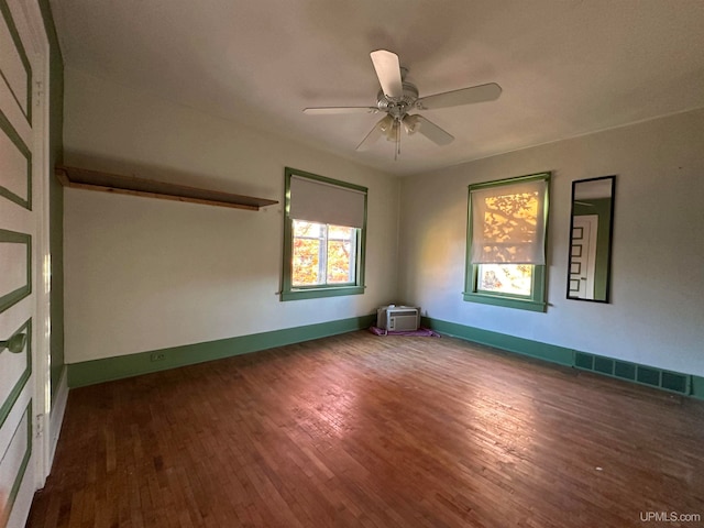 empty room with ceiling fan and dark hardwood / wood-style flooring