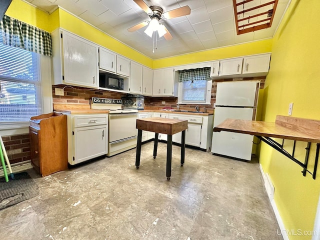 kitchen with a wealth of natural light, white cabinets, and white appliances