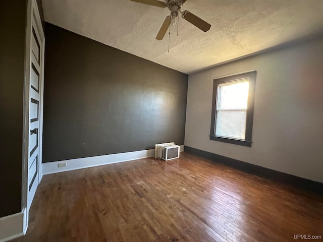 empty room featuring lofted ceiling, a textured ceiling, dark wood-type flooring, and ceiling fan