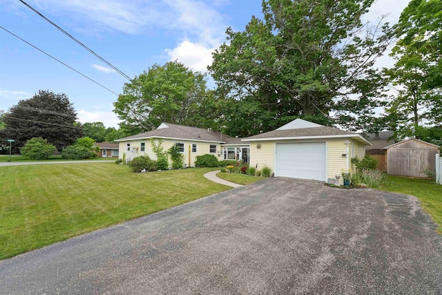 single story home featuring a storage shed, a front lawn, and a garage