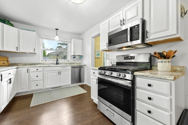 kitchen featuring stainless steel appliances, pendant lighting, dark hardwood / wood-style floors, and white cabinets