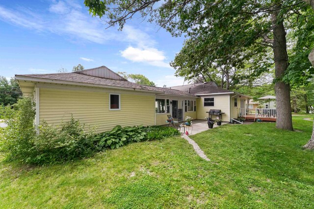 rear view of house featuring a yard, a deck, and a patio area