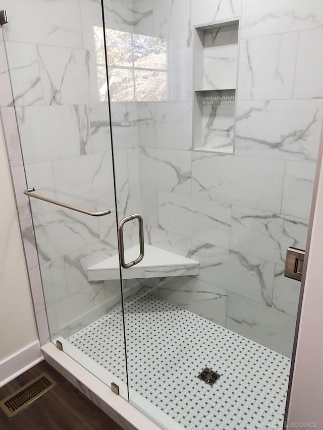 bathroom featuring a shower with door