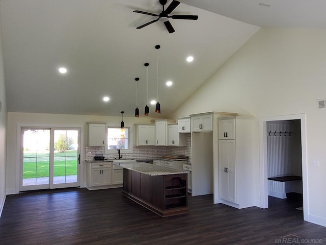 kitchen featuring dark wood-type flooring, a center island, and high vaulted ceiling