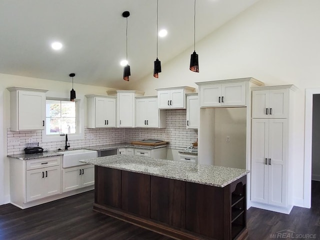 kitchen featuring dark wood-type flooring, sink, a kitchen island, and white cabinets