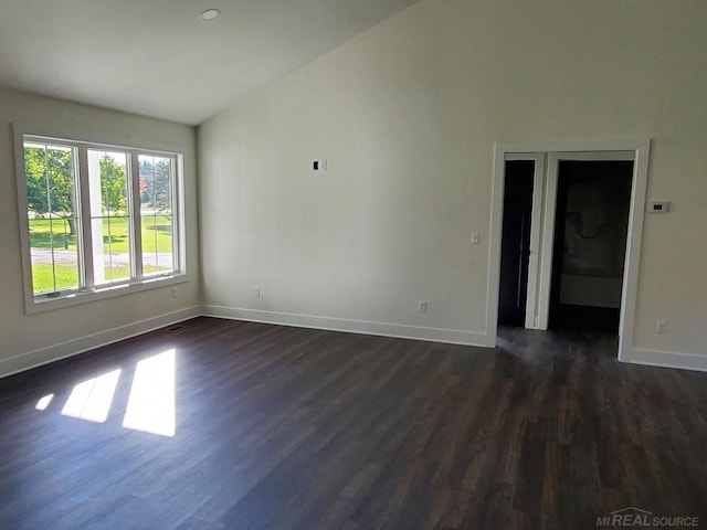 unfurnished room with vaulted ceiling and dark hardwood / wood-style floors