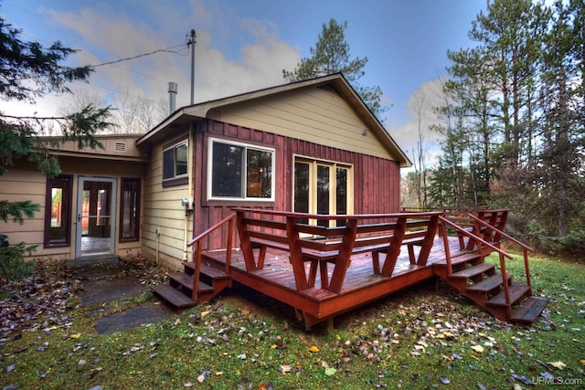 back house at dusk featuring a wooden deck