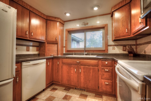 kitchen with white appliances, tasteful backsplash, and sink