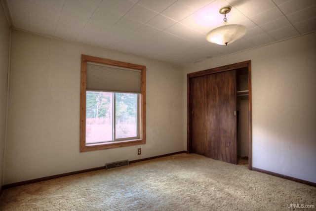 unfurnished bedroom with baseboards, a closet, visible vents, and carpet floors