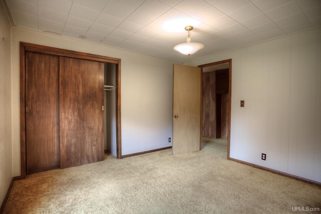 unfurnished bedroom with light colored carpet and a closet