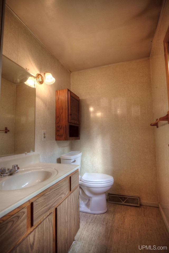 bathroom featuring vanity, hardwood / wood-style flooring, toilet, and tile walls