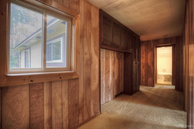 corridor with light carpet and wooden walls