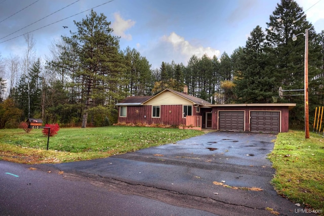 single story home with a chimney, driveway, an attached garage, and a front yard