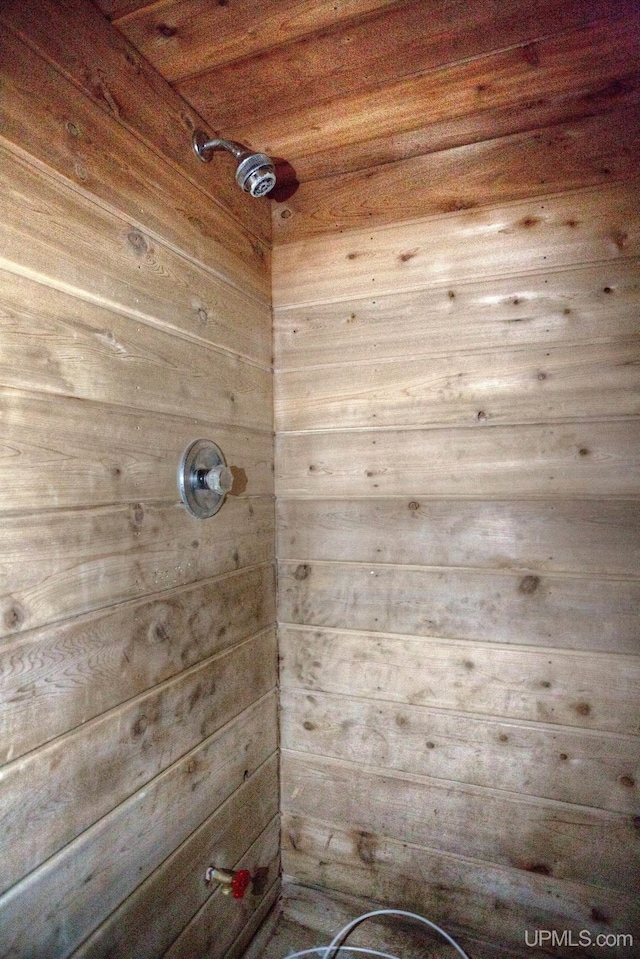 room details with wood ceiling, wood walls, and walk in shower