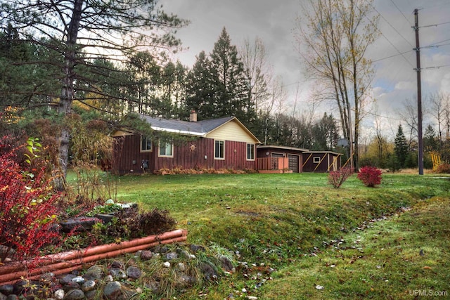 exterior space with a chimney, a yard, and board and batten siding
