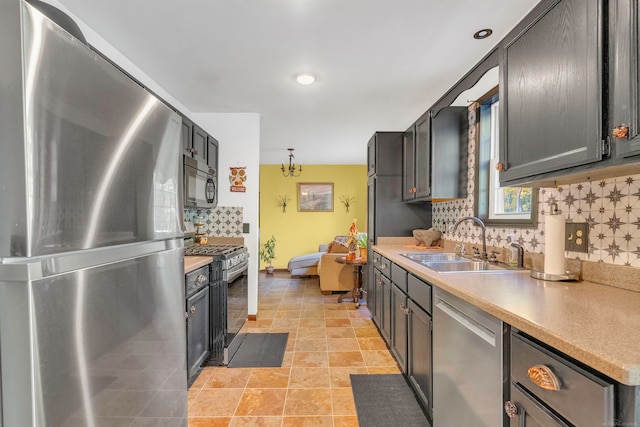 kitchen with backsplash, appliances with stainless steel finishes, and sink