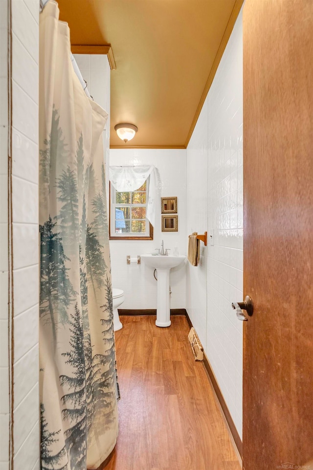 bathroom featuring hardwood / wood-style floors, a shower with curtain, crown molding, and toilet