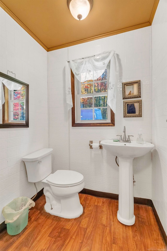 bathroom featuring toilet, tile walls, ornamental molding, and hardwood / wood-style floors