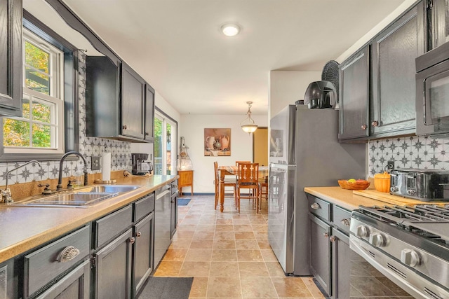 kitchen with sink, decorative light fixtures, backsplash, and plenty of natural light