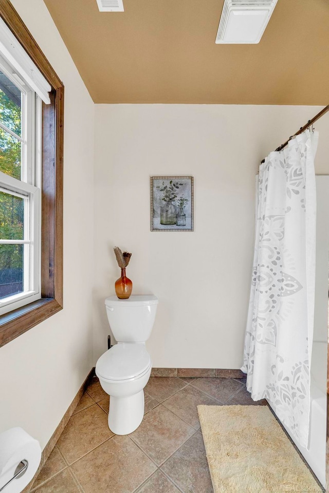 bathroom with tile patterned floors, a shower with curtain, and toilet