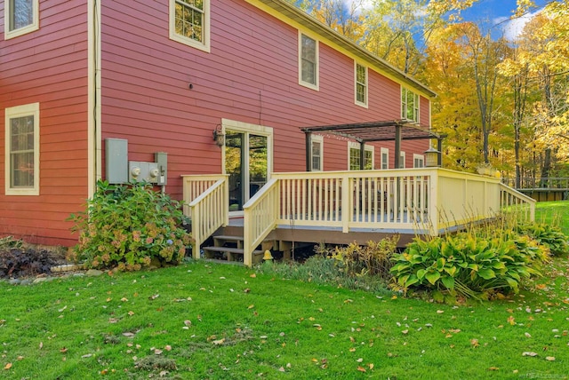 rear view of property featuring a yard, a pergola, and a wooden deck