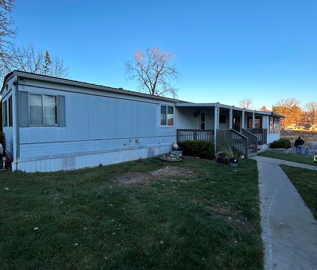 manufactured / mobile home featuring a front lawn and covered porch