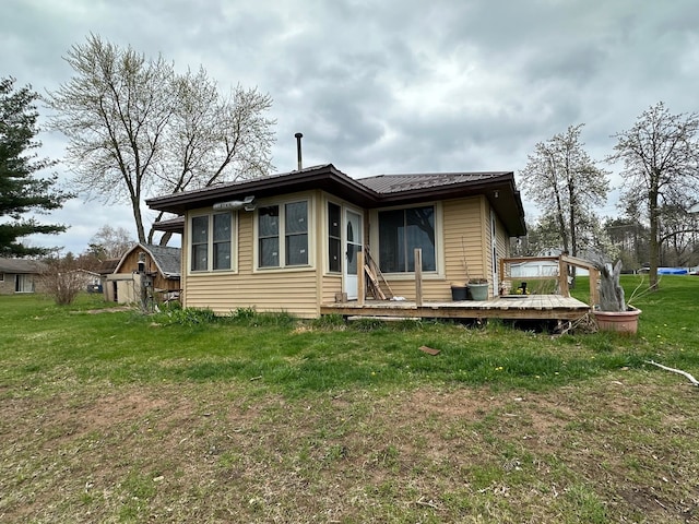 rear view of property featuring a storage shed and a lawn