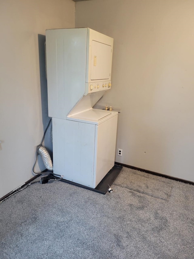 washroom with stacked washer and dryer and carpet flooring