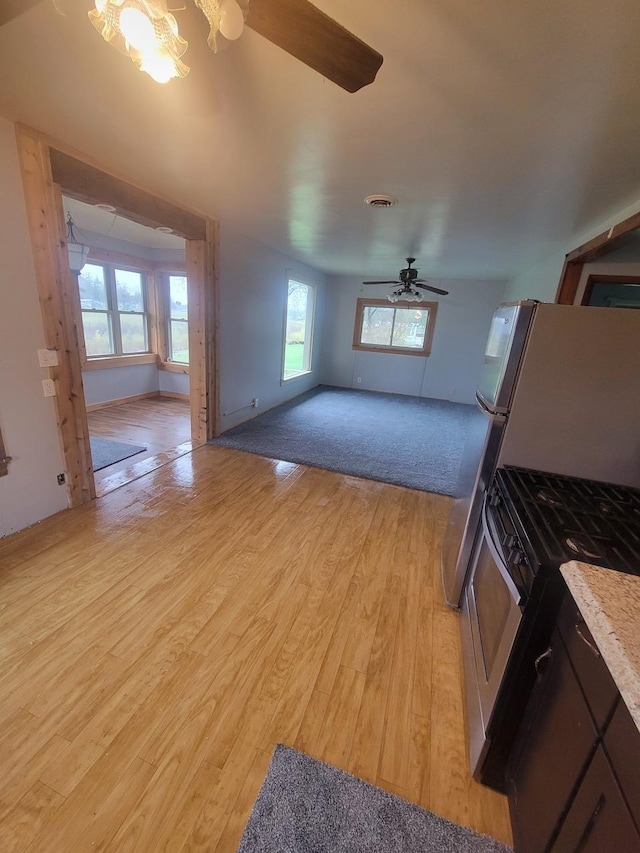 unfurnished living room with light hardwood / wood-style flooring and ceiling fan