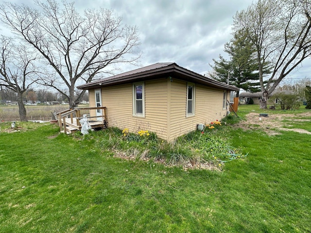 view of side of home featuring a deck and a lawn