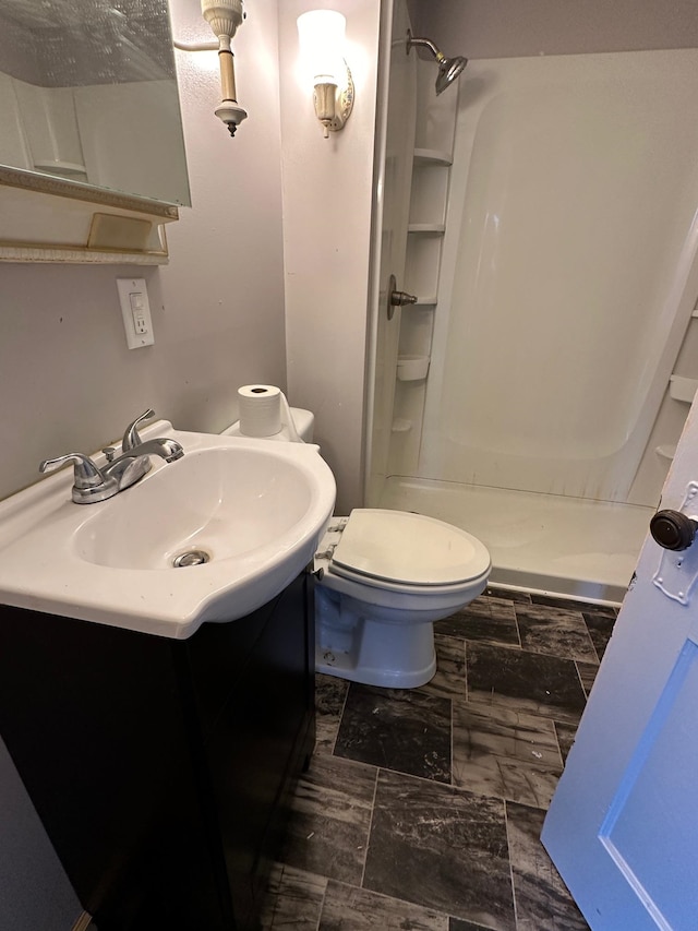 bathroom featuring vanity, toilet, and a shower