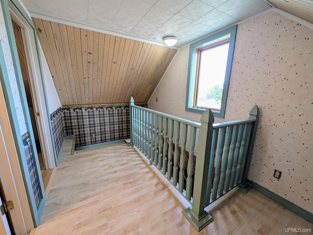 bonus room featuring wood finished floors, vaulted ceiling, and wallpapered walls
