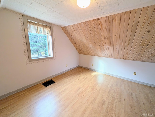 additional living space with vaulted ceiling, baseboards, and wood finished floors