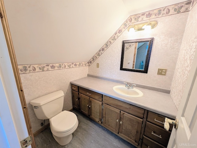 bathroom featuring vanity, toilet, wood finished floors, a wainscoted wall, and vaulted ceiling